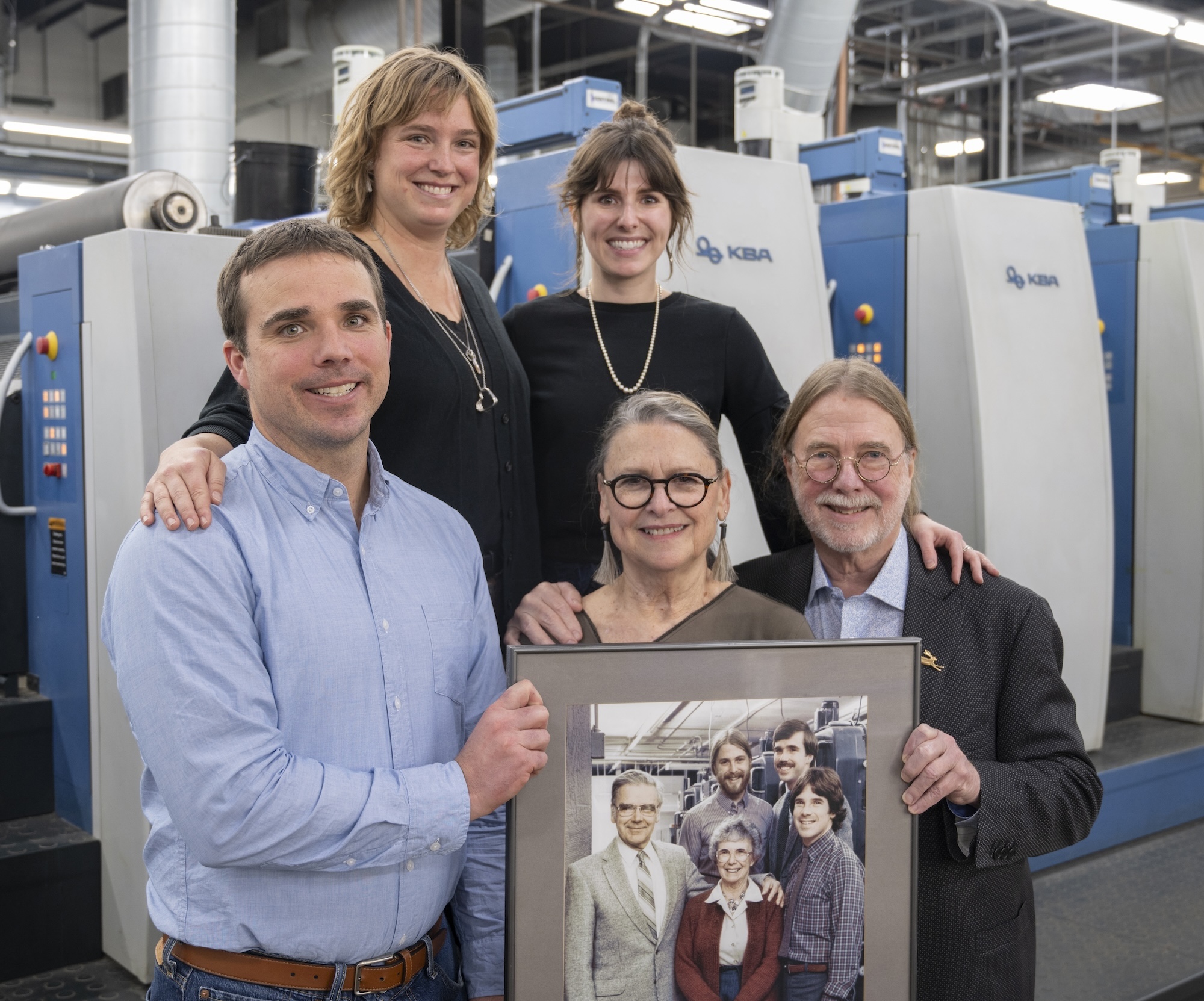 Photo of Bolger's 3rd and 2nd Generation of owners holding a picture of the 1st Generation